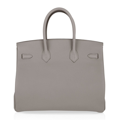 Calm Asphalt Grey Gentle Pebbled Grain Spacious Structured Hand Tote With Seamless Fine Stitching, Polished Golden Twist Lock Hardware And Matching Suspended Textured Tag Striped Metal Padlock Charm