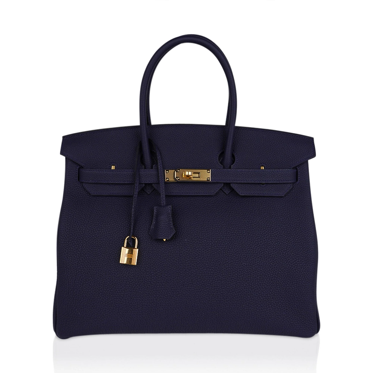 Saturated Midnight Navy Soft Subtle Pebbled Grain Roomy Structured Hand Tote With Seamless Uniform Stitching, Polished Golden Twist Lock Hardware And Matching Suspended Textured Tag Striped Metal Padlock Charm