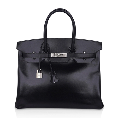 Sleek Jet Black Mirror-Sheen Polished Roomy Structured Hand Tote With Fine Tight Edge Stitching, Intricately Engraved Silvery Twist Lock Hardware And Matching Glossy Tag Etched Striped Metal Padlock Charm