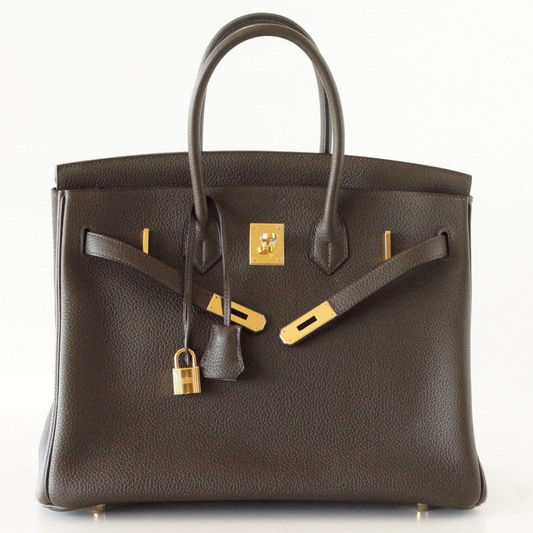 Deep Bronzed Olive Matte Pebbled Grain Spacious Structured Hand Tote With Cross Front Golden Lock Plates, Matching Suspended Textured Tag And Ridged Golden Metal Padlock Charm