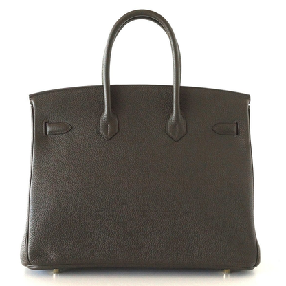 Deep Bronzed Olive Matte Pebbled Grain Spacious Structured Hand Tote With Cross Front Golden Lock Plates, Matching Suspended Textured Tag And Ridged Golden Metal Padlock Charm